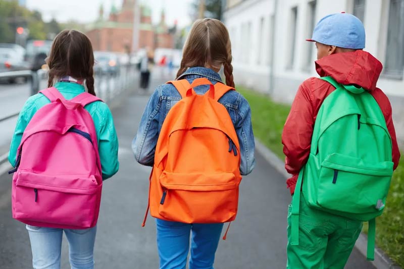 Photo of children walking with backpacks